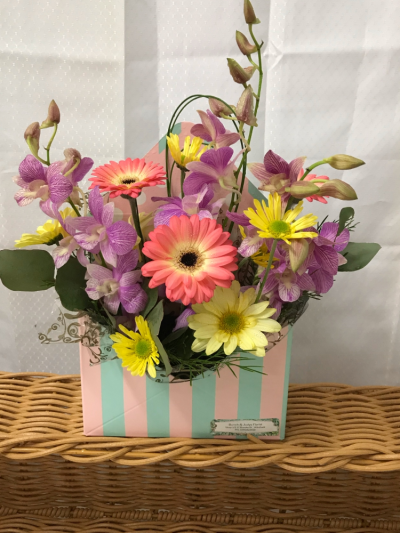 Envelope Box - An envelope shaped box of assorted blooms that may include orchids Lily’s carnations Gerberas, & assorted fresh flowers.Great for a work friend , hospital , or from any occasion. Some flowers may vary due to availability or a similar substitute will be used.& box colours may vary due to availability.